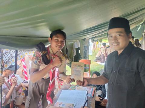 Ketua Bawaslu Kota Pekalongan memberikan hadiah buku kepada peserta yang menjadi pemenang pada sesi tanya jawab Ketua Bawaslu Kota Pekalongan dengan peserta di Stand Saka Adhyasta Pemilu