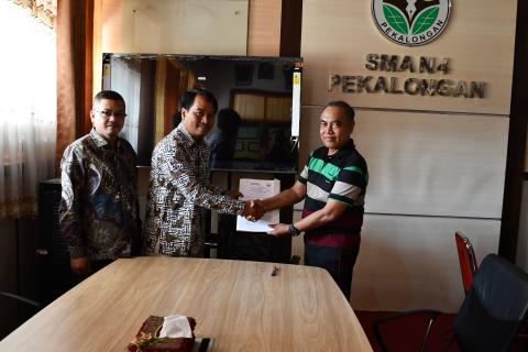 jabat tangan Ketua Bawaslu Kota Pekalongan dan Kepala SMA N 4 Kota Pekalongan setelah penandatanganan MoU